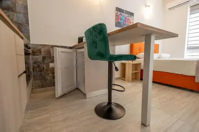 a green chair in a small room with a bed at Studio in Limassol Coast in Limassol