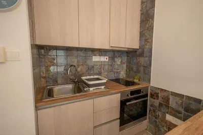 a kitchen with wooden cabinets and a sink at Studio in Limassol Coast in Limassol