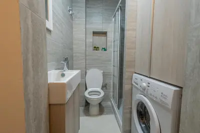 a bathroom with a toilet and a sink and a washing machine at Studio in Limassol Coast in Limassol