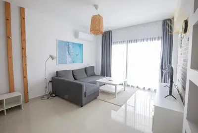 a living room with a gray couch and a window at Sea view Remus Family 2 bdr apartment in Nicosia