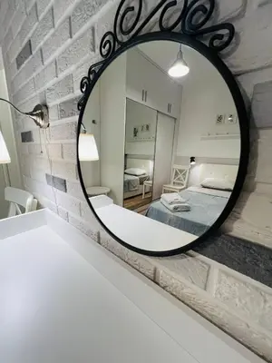 a mirror on a wall with a bed in a room at Sea view Remus Family 2 bdr apartment in Nicosia