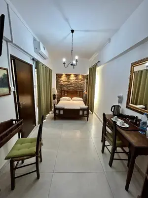 a bedroom with a bed and a table and chairs at Kipros Accommodation in Nicosia