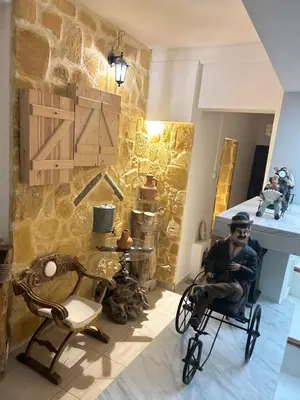 a man sitting in a chair in a room with a stone wall at Kipros Accommodation in Nicosia