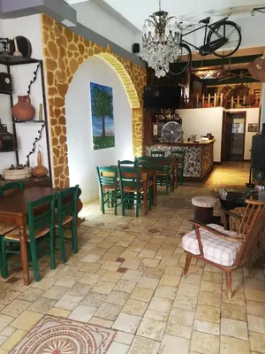 a dining room with green chairs and tables at Kipros Accommodation in Nicosia