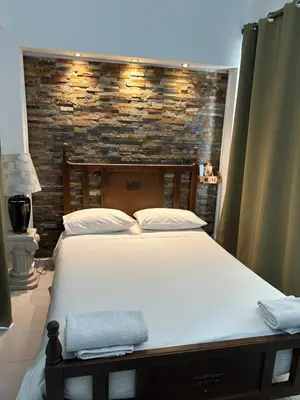 a bedroom with a large bed and a brick wall at Kipros Accommodation in Nicosia