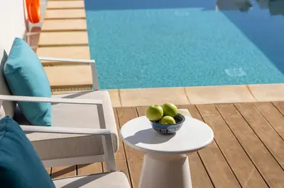 a bowl of fruit on a table next to a pool at Protaras Seafront Villa Galene Del Mar in Protaras