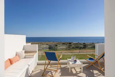a living room with a couch and chairs and the ocean at Protaras Seafront Villa Galene Del Mar in Protaras
