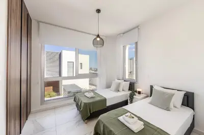 two beds in a room with a window at Protaras Sol e Mar Villa 2 in Protaras