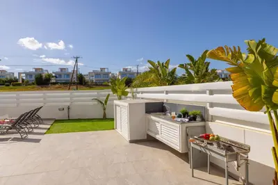 a patio with a table and a grill on a balcony at Protaras Sol e Mar Villa 2 in Protaras