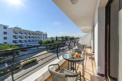 a balcony with a table and chairs and a view at Nissi Apartment #101 in Ayia Napa