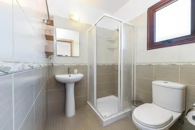 a bathroom with a toilet and a shower and a sink at Nissi Apartment #101 in Ayia Napa