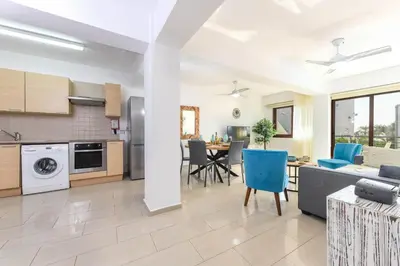 a kitchen and living room with a couch and a table at Nissi Apartment #101 in Ayia Napa