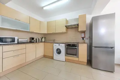 a kitchen with a refrigerator and a washing machine at Nissi Apartment #101 in Ayia Napa