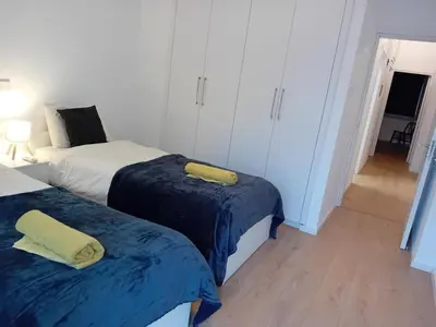 a bedroom with two beds with blue sheets at Spacious Dasoudi Beach Apt 3br in Limassol