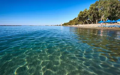 a view of a beach with chairs and umbrellas at Spacious Dasoudi Beach Apt 3br in Limassol