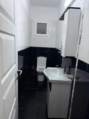 a white bathroom with a toilet and a sink at Royal Sun Comfortable Villa in Larnaka