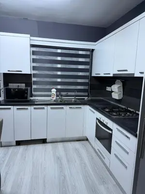 a kitchen with white cabinets and a sink at Royal Sun Comfortable Villa in Larnaka