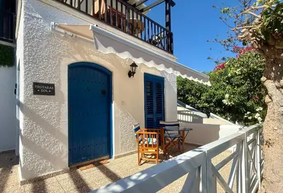 a house with blue doors and chairs on a porch at Protaras Sol 2 Bedroom Holiday Let Apartment in Protaras