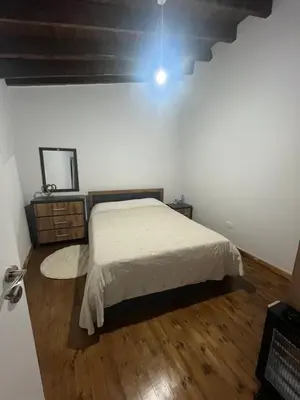 a bedroom with a bed and a wooden floor at Το Αρχοντικόν in Ayvaryara