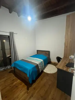a bedroom with a bed and a wooden floor at Το Αρχοντικόν in Ayvaryara
