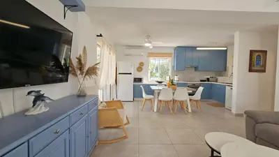 a kitchen and living room with blue cabinets at Andreotis Garden in Protaras