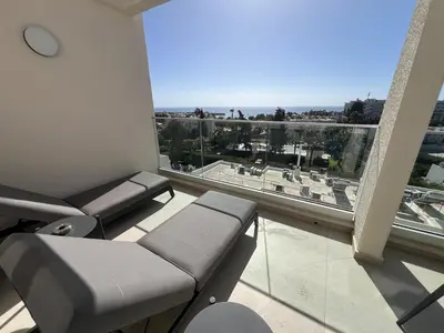 a room with a chair and a couch and a large window at Marina Sea Breeze Apartment, Sleeps 8, Free Wi-Fi in Limassol