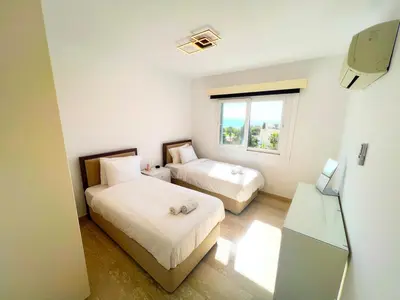 a small bedroom with two beds and a window at Marina Sea Breeze Apartment, Sleeps 8, Free Wi-Fi in Limassol