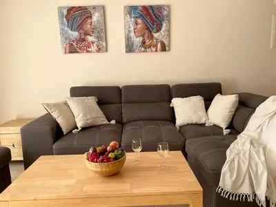 a living room with a couch and a table with a bowl of fruit at NISSI Elena BEACH apt in Ayia Napa