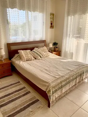 a bed in a bedroom with a large window at NISSI Elena BEACH apt in Ayia Napa