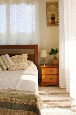 a bedroom with a bed and a table with a plant at NISSI Elena BEACH apt in Ayia Napa