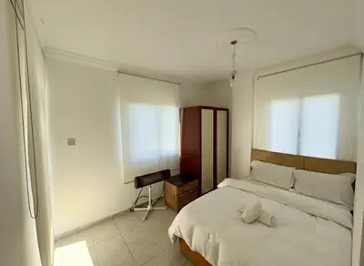 a bedroom with a large white bed and a window at Kyrenia City Center Apartment in Kambia