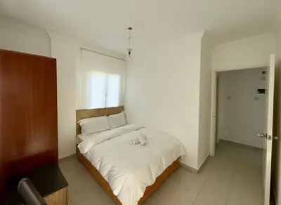 a bedroom with a large bed with white sheets at Kyrenia City Center Apartment in Kambia