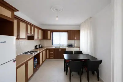 a kitchen with a table and some chairs in it at Girne KKTC in Anayia