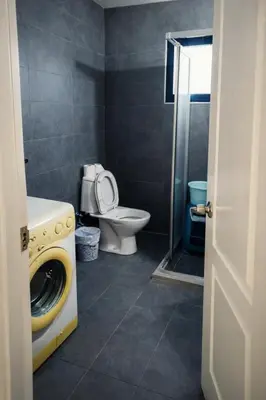 a bathroom with a washing machine and a toilet at Girne KKTC in Anayia