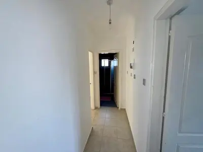 a hallway with a white wall and a door at Girne KKTC in Anayia
