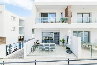 a house with a balcony with a table and chairs at Rons House in Paralimni