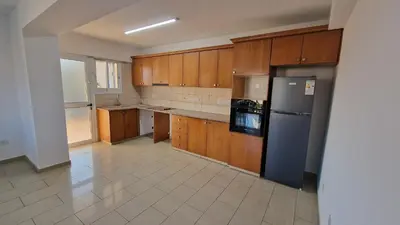 a kitchen with wooden cabinets and a stainless steel refrigerator at Limassol Great in Limassol