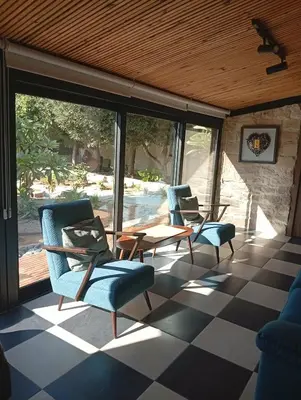 a screened porch with chairs and a table on a checkered floor at Ζεν σπίτι in Limassol