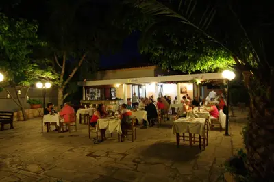 a group of people sitting at a restaurant at night at The Love Nest in Pissouri