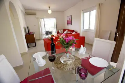 a living room with a table with a vase of flowers at The Love Nest in Pissouri
