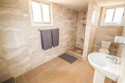 a bathroom with a sink and a toilet and a shower at Orchard View Cottage in Maroni