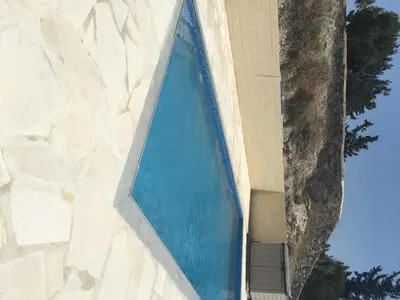 a large blue swimming pool on the side of a building at Orchard View Cottage in Maroni