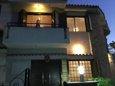 a person sitting on the balcony of a house at night at Nikola's House in Limassol
