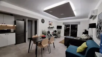 a living room with a couch and a table with chairs at Nissi Golden Sands Paradi in Ayia Napa