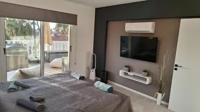 a bedroom with a large bed with a flat screen tv at Nissi Golden Sands Paradi in Ayia Napa
