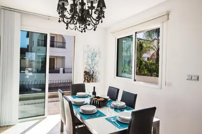 a dining room with a table and chairs and a chandelier at Seaspray in Protaras
