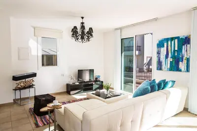 a living room with a white couch and blue pillows at Seaspray in Protaras
