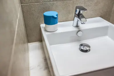 a white bathroom sink with a blue container on it at Seaspray in Protaras