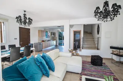 a living room with a white couch and blue pillows at Seaspray in Protaras