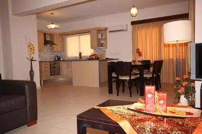 a kitchen and a living room with a table in a room at Bay Villas in Pissouri